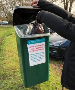 Councillor putting dog-poo bag in bin