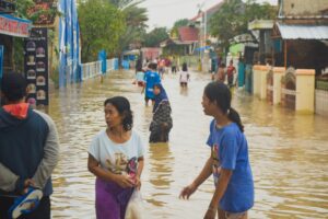 asian people wading in flood water